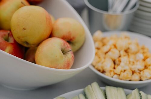 An inviting platter of fresh fruit and vegetables with a dipping sauce, perfect for a healthy snack.