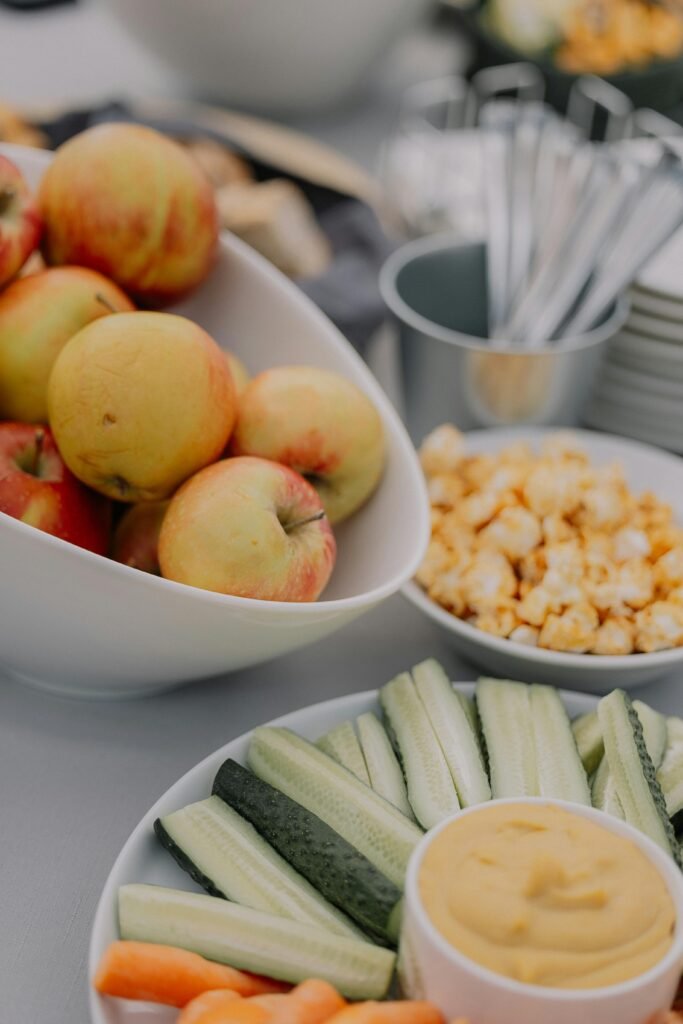 An inviting platter of fresh fruit and vegetables with a dipping sauce, perfect for a healthy snack.