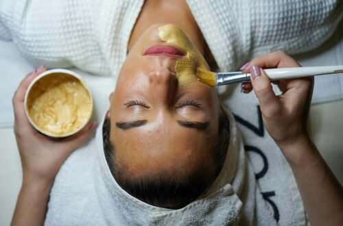 A woman enjoying a gold facial mask for relaxation and skincare at a spa.