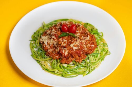 A vibrant dish featuring zucchini noodles topped with savory Bolognese and cherry tomatoes.
