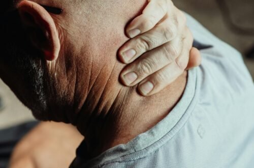 Man with neck pain holding his neck in discomfort, conveying tension or stress.