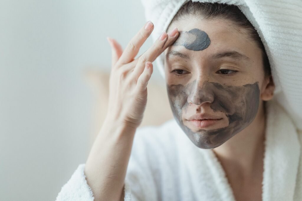 Adult woman relaxing with a clay face mask, enhancing skin health and wellness indoors.