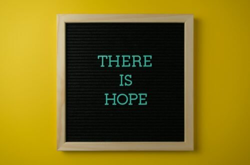 Letter board with 'THERE IS HOPE' message against a vibrant yellow backdrop.
